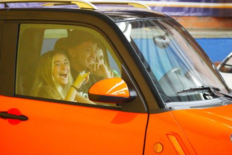 High School students laughing inside one of the cars being displayed in the fair. The Orange cars are made by Celcia, and the project showcased how sustainable they are and how they can improve the world environmentally and in other situations.