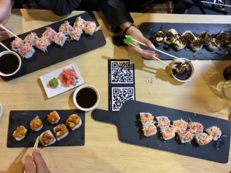 A group of five school friends order different plates from the kaiten sushi, to try a variety of flavors that Sushi Train offers customers. 