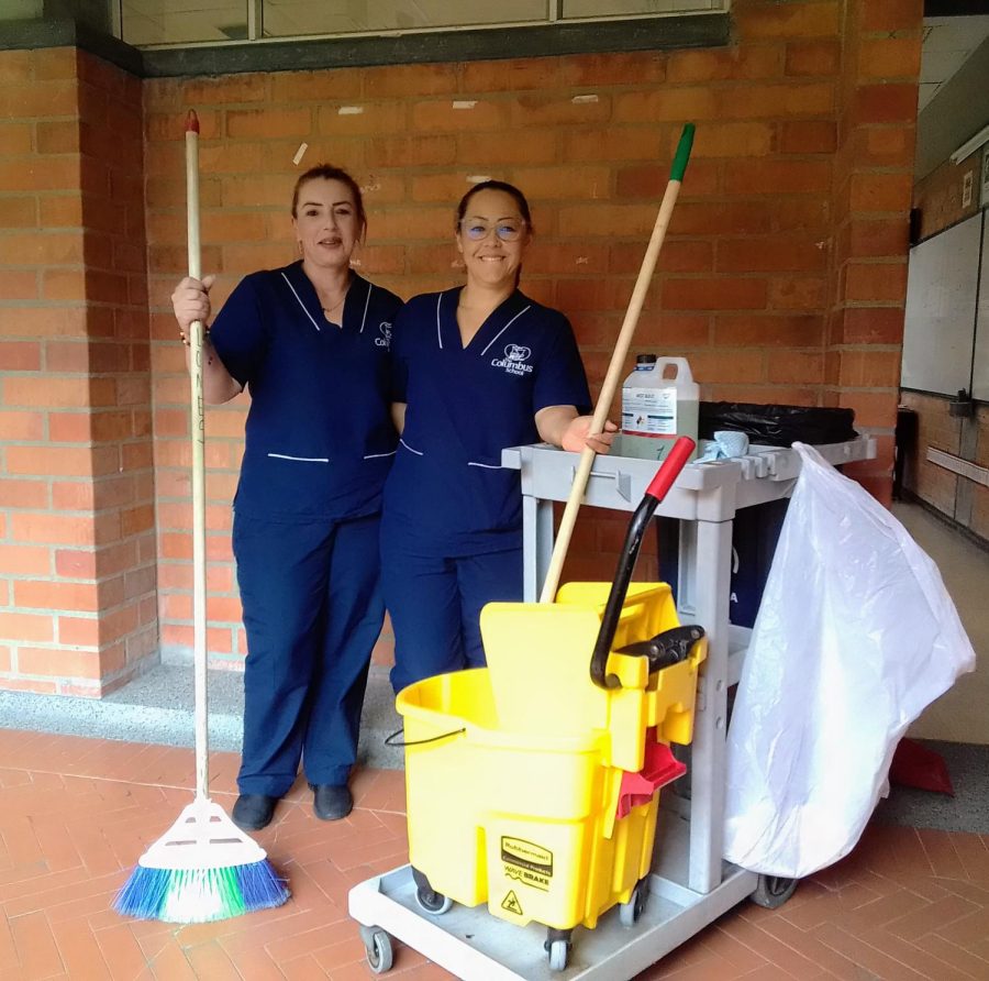 General Service Employees Gloria Martinez (L) and Diana Arango at work in the halls of the TCS High School. 