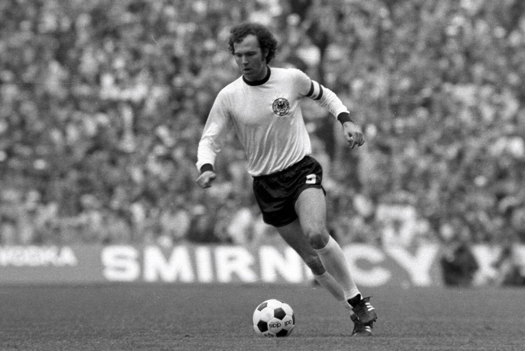 Franz+Beckenbauer+sprints+with+a+ball+in+his+feet+during+an+international+game+with+Germany.%0A
