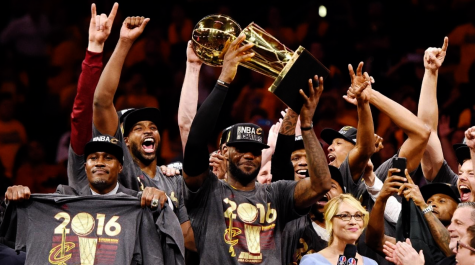 Lebron James lifting the Larry OBrien Trophy as he and the Cleveland Cavaliers celebrate, shortly after winning the 2016 NBA Finals against Stephen Curry and the Golden State Warriors.