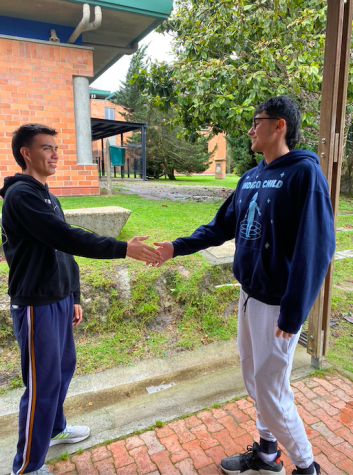 TCS Personero Mateo Zarate shakes Senior Andres Lopera´s hand in front of the HS cafeteria on September 21.  