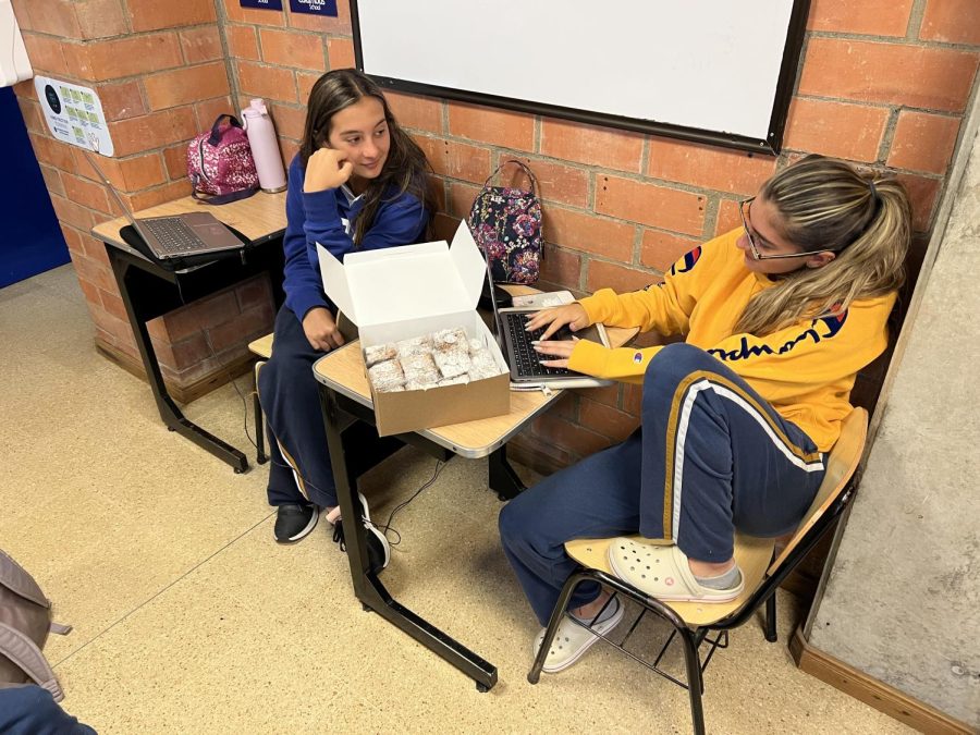 Maria Melez and Maria Camila Agudelo discuss a new article in journalism class. 